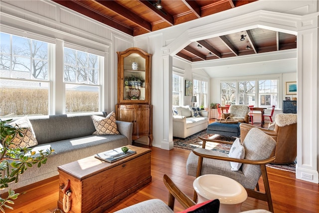 living room with a wealth of natural light, beamed ceiling, wood-type flooring, and wood ceiling