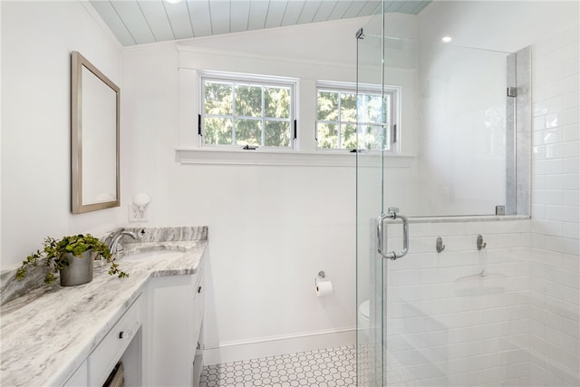 bathroom featuring baseboards, a shower stall, vanity, and lofted ceiling