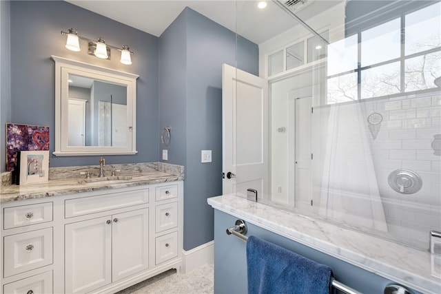 full bathroom with a tile shower, visible vents, and vanity