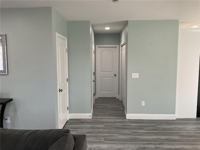 hallway featuring recessed lighting, baseboards, and wood finished floors