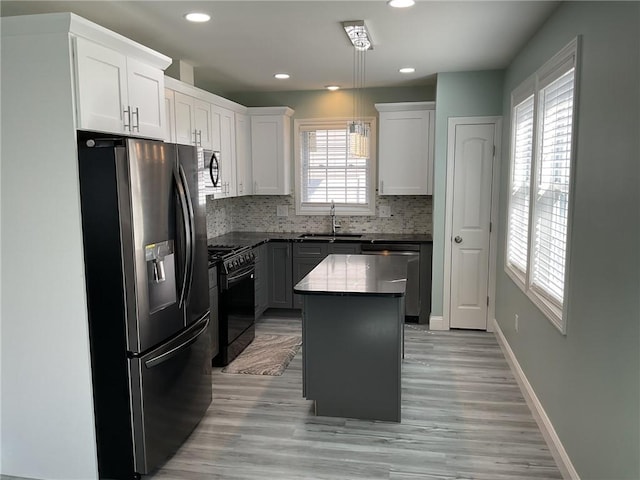 kitchen featuring a sink, backsplash, a center island, stainless steel appliances, and baseboards