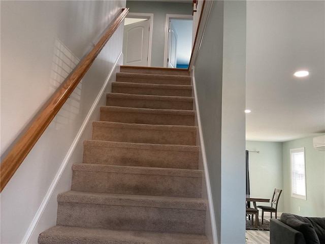 staircase featuring recessed lighting and a wall mounted air conditioner