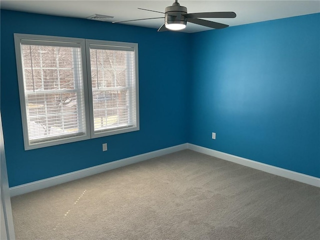 carpeted empty room with visible vents, baseboards, and ceiling fan