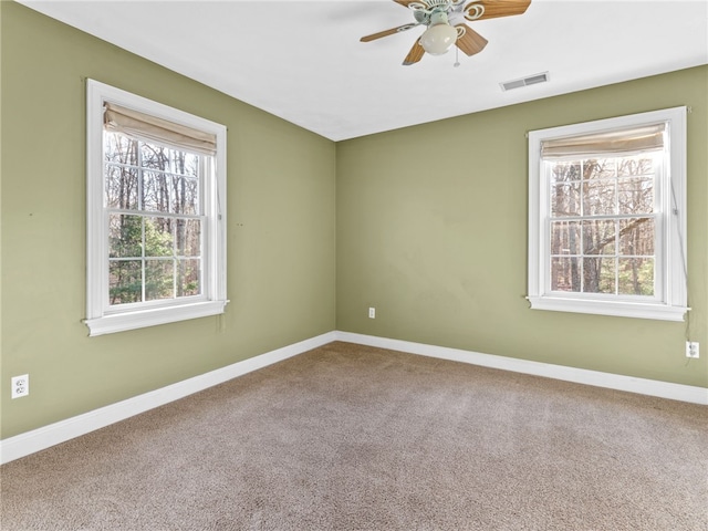 empty room featuring visible vents, baseboards, carpet, and ceiling fan