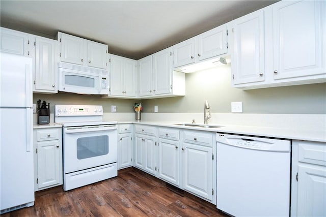 kitchen with white appliances, dark wood finished floors, a sink, light countertops, and white cabinets