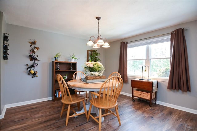 dining area featuring dark wood-style floors, an inviting chandelier, and baseboards