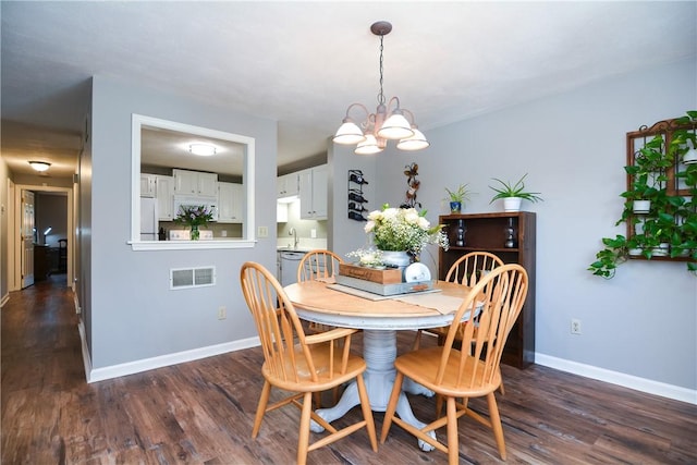 dining room featuring a chandelier, visible vents, baseboards, and dark wood-style flooring