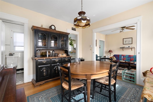 dining area with wood finished floors and ceiling fan