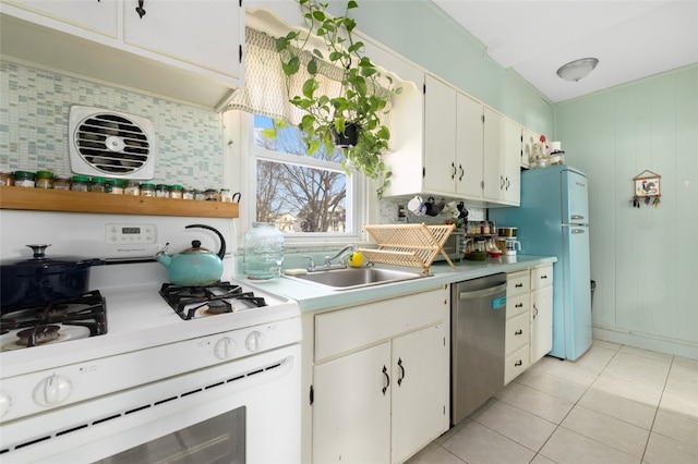 kitchen featuring white appliances, light tile patterned floors, a sink, light countertops, and tasteful backsplash