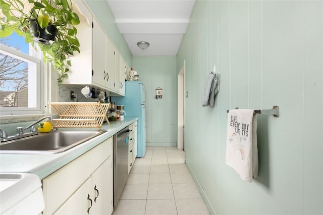 kitchen featuring light tile patterned floors, a sink, decorative backsplash, light countertops, and dishwasher