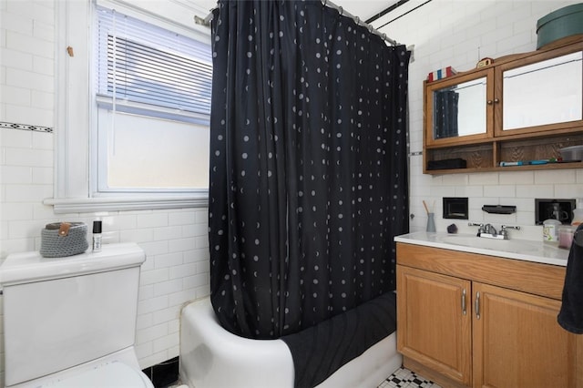 bathroom featuring vanity, tile walls, toilet, and shower / bath combo