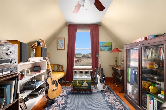 interior space with vaulted ceiling, radiator heating unit, wood finished floors, and ceiling fan