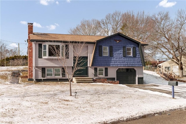 bi-level home with a chimney and an attached garage