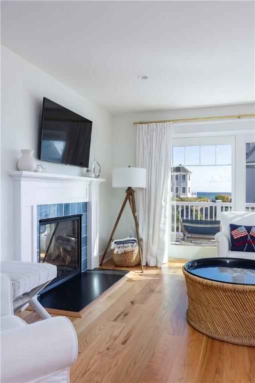 living room featuring a tiled fireplace and wood finished floors