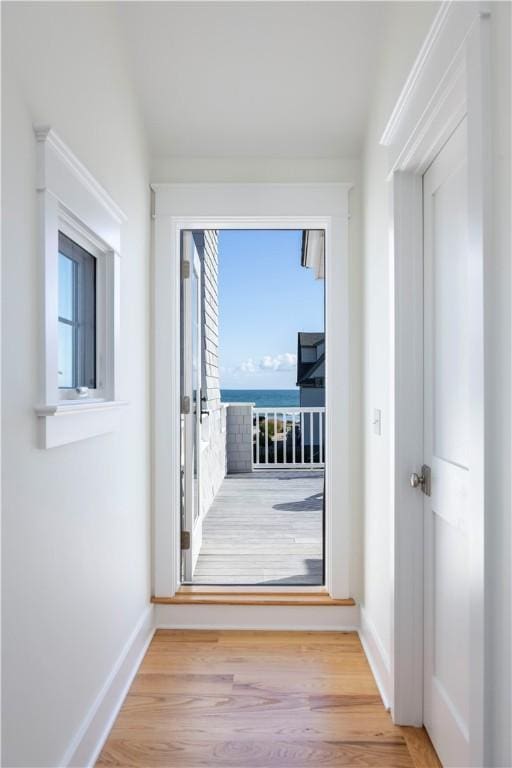 corridor with baseboards and wood finished floors