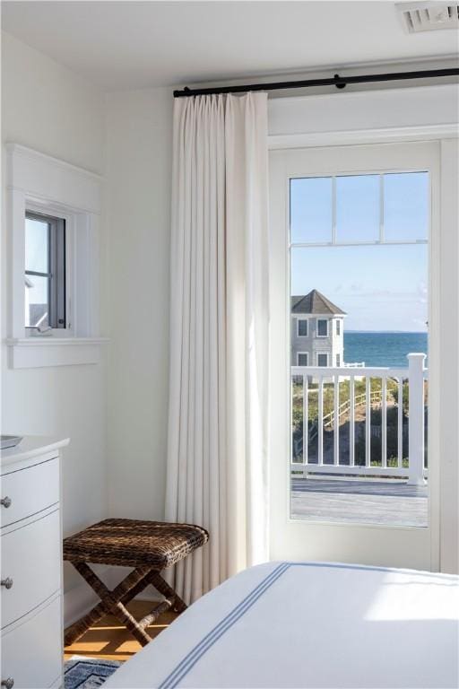 bedroom with visible vents and a water view