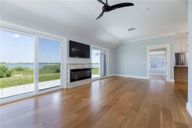 unfurnished living room with a ceiling fan, a glass covered fireplace, wood finished floors, baseboards, and vaulted ceiling