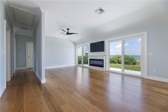 unfurnished living room featuring ceiling fan, visible vents, attic access, and wood finished floors