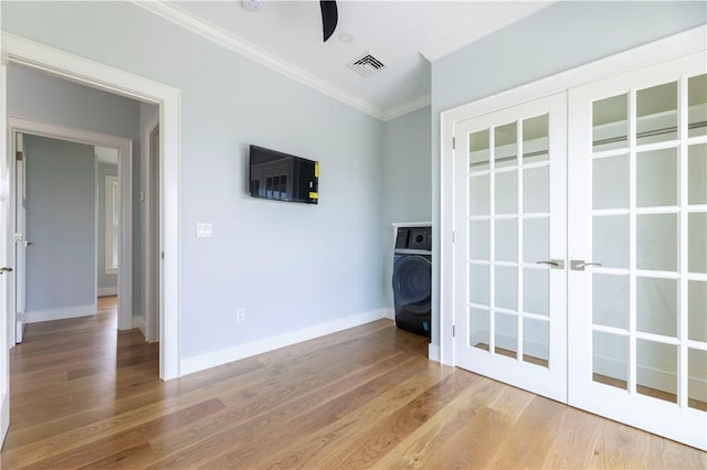 interior space with visible vents, ornamental molding, wood finished floors, baseboards, and washer / dryer