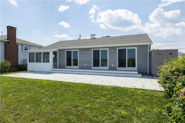 back of house with fence, a lawn, a sunroom, and a patio area