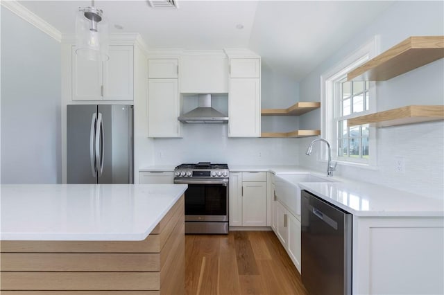 kitchen featuring open shelves, a sink, dark wood-style floors, stainless steel appliances, and wall chimney exhaust hood