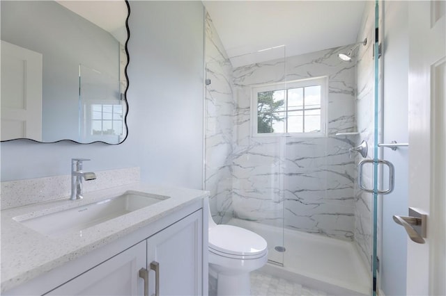 bathroom featuring vanity, toilet, and a marble finish shower