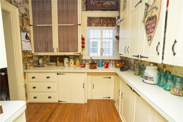 kitchen featuring white cabinets, light wood-type flooring, and light countertops