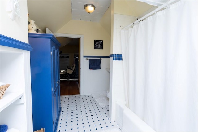 full bathroom with lofted ceiling and a shower with curtain