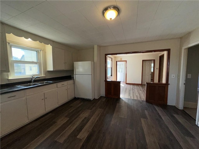 25 N Union St, Lincoln, RI 02865 - kitchen featuring a sink, freestanding refrigerator, dark countertops, dark wood-style floors, and white cabinets