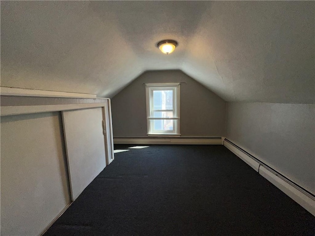25 N Union St, Lincoln, RI 02865 - bonus room featuring a baseboard radiator, vaulted ceiling, dark colored carpet, and a textured ceiling