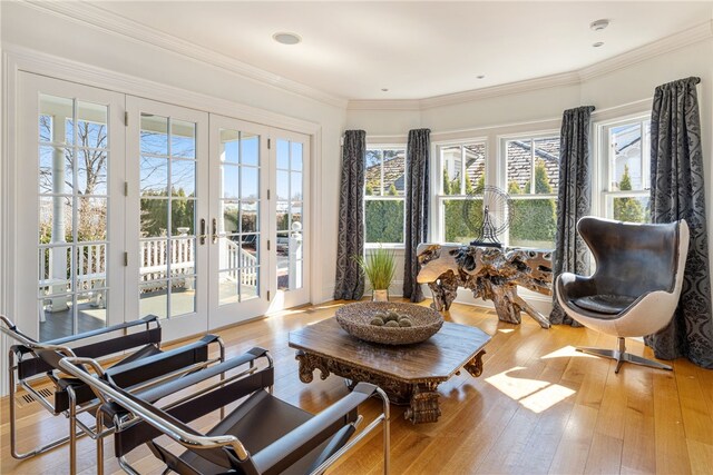 sunroom / solarium featuring wood-type flooring, crown molding, and french doors