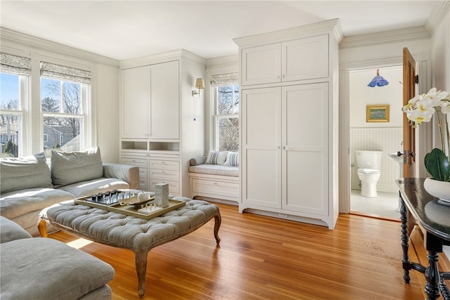 sitting room with crown molding and light wood-style floors
