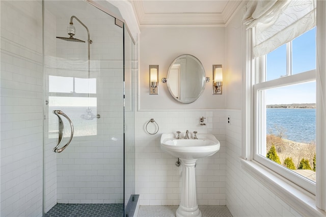 full bathroom with a stall shower, plenty of natural light, a water view, and crown molding
