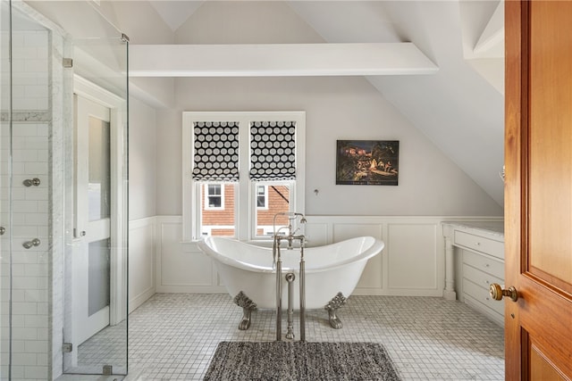 bathroom featuring a freestanding bath, vaulted ceiling, a shower stall, and a decorative wall
