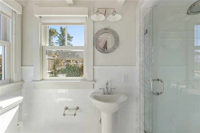 bathroom featuring tile walls and a stall shower