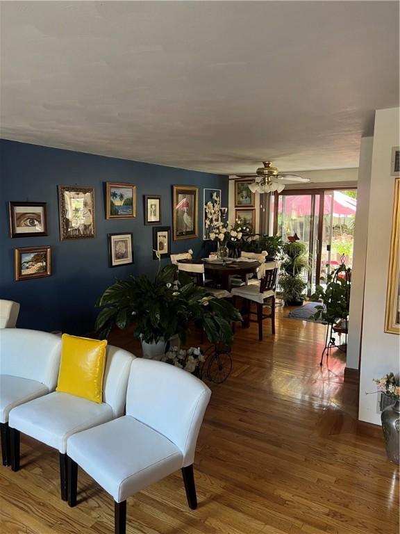 living area featuring wood finished floors, visible vents, and ceiling fan