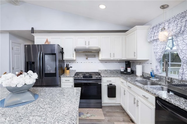 kitchen featuring vaulted ceiling, stainless steel appliances, under cabinet range hood, a sink, and white cabinets