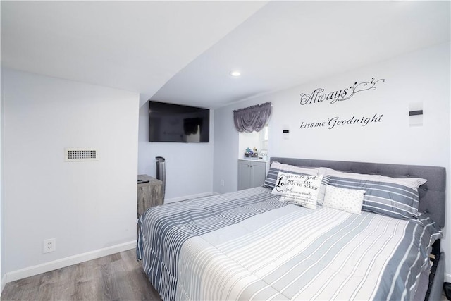 bedroom featuring baseboards, visible vents, wood finished floors, and recessed lighting