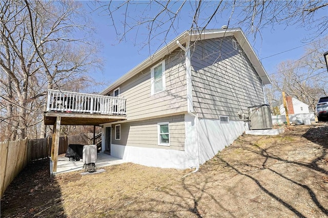 rear view of property featuring a fenced backyard, a wooden deck, and a patio area