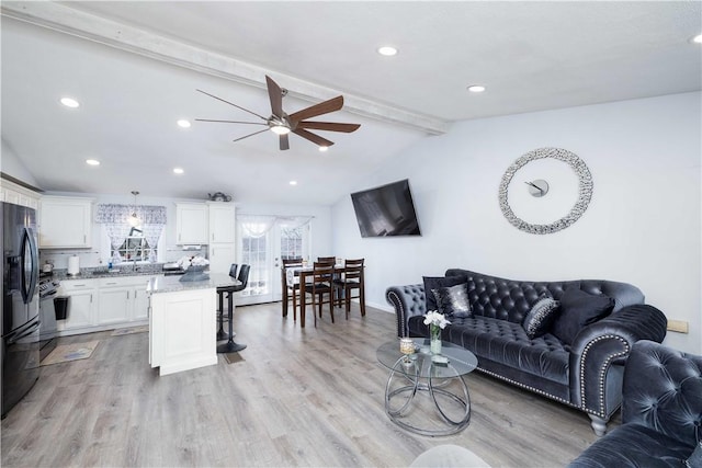 living area featuring a ceiling fan, lofted ceiling with beams, light wood-style floors, and recessed lighting