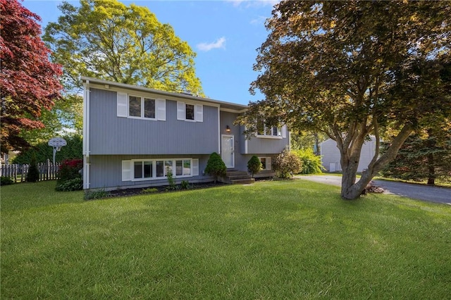 bi-level home with driveway, a front yard, and fence