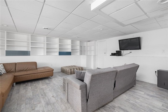 living room featuring wood finished floors, baseboards, and a drop ceiling