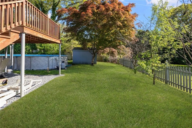 view of yard featuring a storage unit, an outdoor pool, an outdoor structure, and a fenced backyard