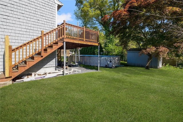 view of yard featuring a deck, stairs, and an outdoor pool