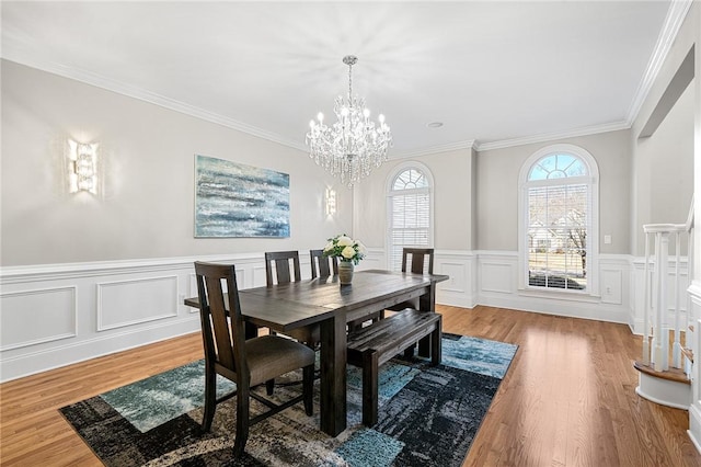 30 Lenihan Ln, East Greenwich, RI 02818 - dining area with a chandelier, wood finished floors, ornamental molding, a decorative wall, and wainscoting
