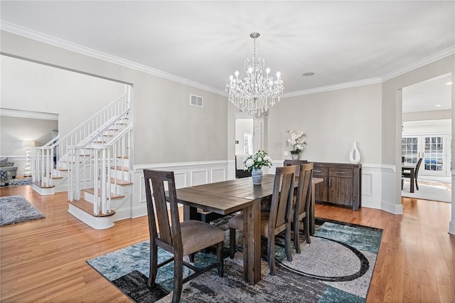 30 Lenihan Ln, East Greenwich, RI 02818 - dining room featuring stairs, light wood-style flooring, a chandelier, ornamental molding, and a decorative wall