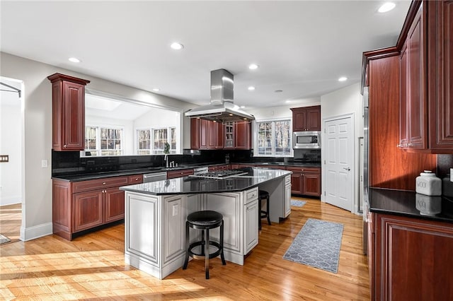 30 Lenihan Ln, East Greenwich, RI 02818 - kitchen featuring stainless steel appliances, island range hood, a center island, backsplash, and a kitchen breakfast bar