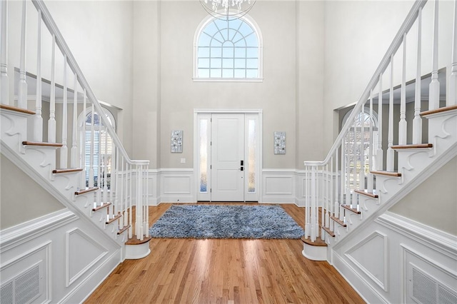 30 Lenihan Ln, East Greenwich, RI 02818 - foyer entrance with stairs, a towering ceiling, a decorative wall, wood finished floors, and a wainscoted wall