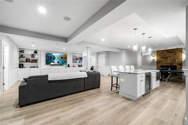 30 Lenihan Ln, East Greenwich, RI 02818 - living room with wine cooler, a fireplace, light wood finished floors, built in shelves, and recessed lighting