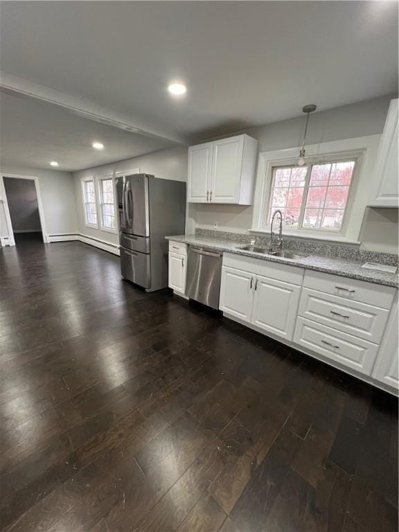 kitchen with dark wood-style flooring, light stone counters, a sink, stainless steel appliances, and recessed lighting
